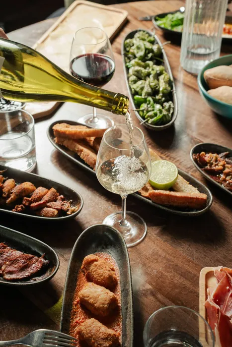 Plats à partager et vin blanc servis à table